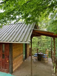 a porch of a cabin with a table and chairs at Forest House Ninokristali in Visoko