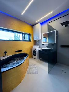 ein Badezimmer mit einer Badewanne und einem Waschbecken in der Unterkunft LUXUS-PENTHOUSE mit Weitblick über Graz in Graz