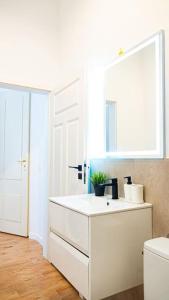 a white bathroom with a sink and a mirror at Komfortowy Apartament w Centrum in Warsaw