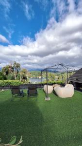 two chairs and a swing set on the grass at Puerto Manzano Suites by Visionnaire in Villa La Angostura