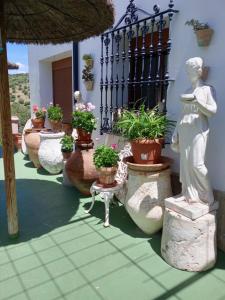 een standbeeld van een vrouw op een veranda met potplanten bij Casa Paco in El Bosque