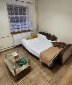 ルブニエビツェにあるApartament Lubniewiceのベッドルーム(大型ベッド1台、ガラステーブル付)