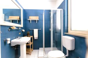 een blauwe badkamer met een wastafel en een douche bij Casa Angela Lipari in Canneto