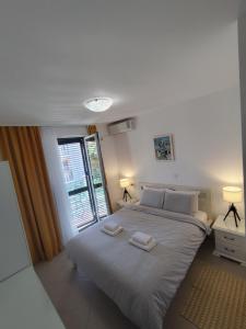 a bedroom with a large bed with two towels on it at Lucky Studios in Herceg-Novi