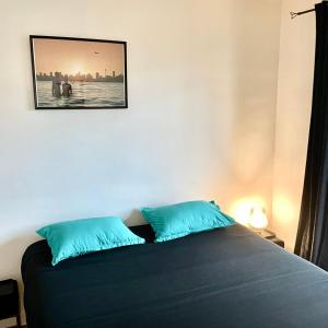 - une chambre avec un lit et 2 oreillers bleus dans l'établissement Appartement vue lac Montreux, à Montreux