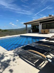 una piscina con sedie e una casa di Villa Pirineus a beautiful villa with pool a Santa Cristina d'Aro