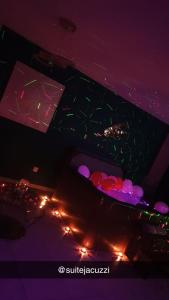 um quarto escuro com uma mesa com luzes em Suite jacuzzi "spa privatif " appartement Jacuzzi em Toulouse