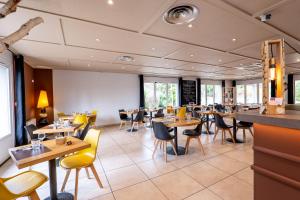 - un restaurant avec des tables et des chaises dans une salle dans l'établissement Kyriad Digne-Les-Bains, à Digne-Les-Bains