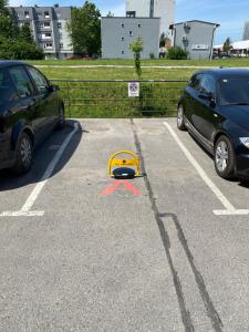 dos autos estacionados en un estacionamiento con un casco amarillo en Apartman “Zara” en Zagreb