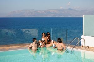 un gruppo di persone sedute in piscina di Marina di Petrolo Hotel & SPA a Castellammare del Golfo