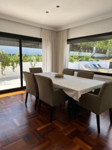 una sala da pranzo con tavolo e sedie bianchi di Villa Pirineus a beautiful villa with pool a Santa Cristina d'Aro
