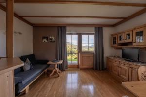 - un salon avec un canapé et une télévision dans l'établissement Residence Burghof, à Alpe di Siusi