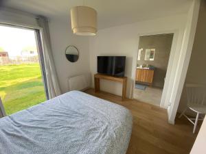 1 dormitorio con 1 cama y TV de pantalla plana en Villa - Cap Blanc-Nez, en Sangatte