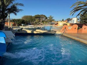 a pool in a resort with a water slide at Casa Luisa Mobil Home in Canet-en-Roussillon