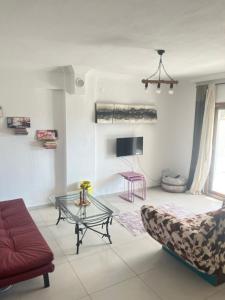 a living room with a couch and a glass table at Azra evleri in Datca