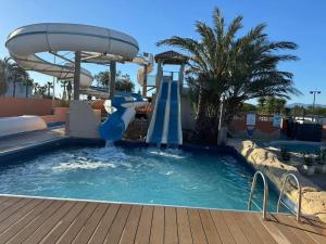 a water slide in a pool at a resort at Casa Luisa Mobil Home in Canet-en-Roussillon +17 photos