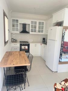 a kitchen with a wooden table and a white refrigerator at Azra evleri in Datca +13 photos
