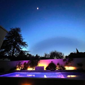 uma vista nocturna de uma piscina com a lua em Les Logis de Cocagne em Saint-Rémy-de-Provence