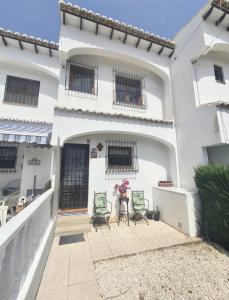 a white house with two chairs and a vase of flowers at LagoVista45 in Torrevieja