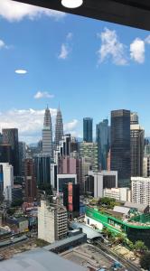 een uitzicht op de skyline van de stad met hoge gebouwen bij Sunset service suite At Times square in Kuala Lumpur