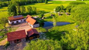 an aerial view of a farm with a house and a pond at Agroturystyka Dzikie Stawy-Mazury in Golubie Wężewskie