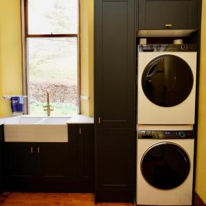 eine Küche mit einer Waschmaschine und einem Waschbecken in der Unterkunft Ardchoile, Cairngorms - Escape Cottages Scotland in Kingussie