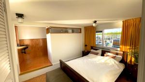 a bedroom with a bed and a window at Casey's Lake View House Boat in Amsterdam