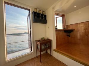 a room with a window with a view of the water at Casey's Lake View House Boat in Amsterdam +20 photos