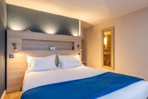 sypialnia z dużym łóżkiem i niebieskim kocem w obiekcie Kyriad Digne-Les-Bains w mieście Digne-les-Bains