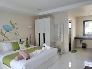 Un dormitorio con una cama blanca con toallas. en Villa LunaSole Samui en Koh Samui