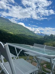 d'une table et de chaises avec vue sur les montagnes. dans l'établissement Gîte Les Géraniums, à Pallud