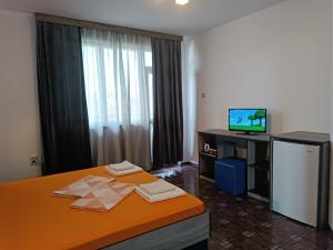 a hotel room with a bed and a television at Coral Family Hotel in Chernomorets