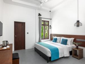 - une chambre avec un grand lit et des oreillers bleus dans l'établissement Fushi Beach Guesthouse, à Fenfushi