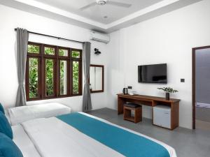 - une chambre avec un lit, une télévision et une fenêtre dans l'établissement Fushi Beach Guesthouse, à Fenfushi