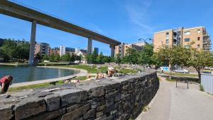 Un grupo de personas sentadas en el césped junto a un muro de contención. en Kjekk urban leilighet, en Stavanger