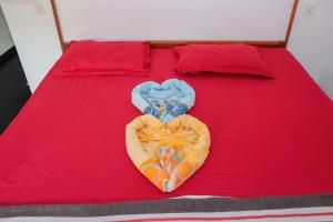 a red bed with two blankets and a heart made out at Emerald Bay in Arugam Bay