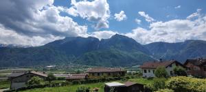 uma aldeia num vale com montanhas ao fundo em Le quattro stagioni em Levico Terme
