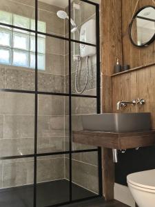 ein Badezimmer mit einer Glasdusche mit Waschbecken in der Unterkunft Rosemary Cottage in Mattishall