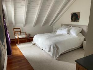 a bedroom with a white bed and a chair at Spacious and stylish Apartment in Zurich in Zürich +31 photos