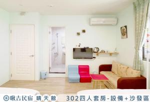 uma sala de estar com um sofá e uma televisão em 啾吉民宿晴天館 em Wujie