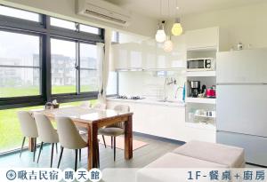 uma cozinha e sala de jantar com mesa e cadeiras em 啾吉民宿晴天館 em Wujie