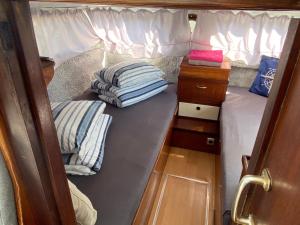 due cuscini sono seduti sul retro di una piccola stanza di Boat Jan van Gent-niet om mee te varen a Jutrijp