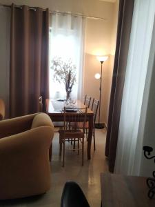 salon ze stołem i krzesłami oraz oknem w obiekcie Maria’s apartment w mieście Amfilochia