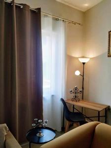 salon z kanapą, stołem i oknem w obiekcie Maria’s apartment w mieście Amfilochia