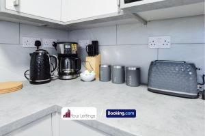 a kitchen counter with appliances on a counter top at 4 Bedroom Contractor House By Your Lettings Short Lets & Serviced Accommodation Peterborough With Free WiFi in Peterborough