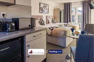 a hotel room with a bed and a kitchen with a table at 4 Bedroom Contractor House By Your Lettings Short Lets & Serviced Accommodation Peterborough With Free WiFi in Peterborough