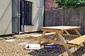 a picnic table and bench in front of a fence at 4 Bedroom Contractor House By Your Lettings Short Lets & Serviced Accommodation Peterborough With Free WiFi in Peterborough