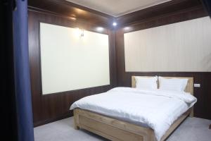 Bett in einem Zimmer mit zwei großen Fenstern in der Unterkunft Mây Núi Homestay in Sa Pa