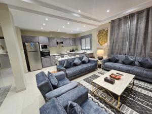شقة فاخرة Modern Apartment of 3 Bedrooms 5 minutes to Haram في المدينة المنورة: غرفة معيشة مع أرائك زرقاء وطاولة
