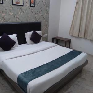 a bedroom with a large white bed with pillows at HOTEL RADHE GUEST HOUSE in Bechiwāra